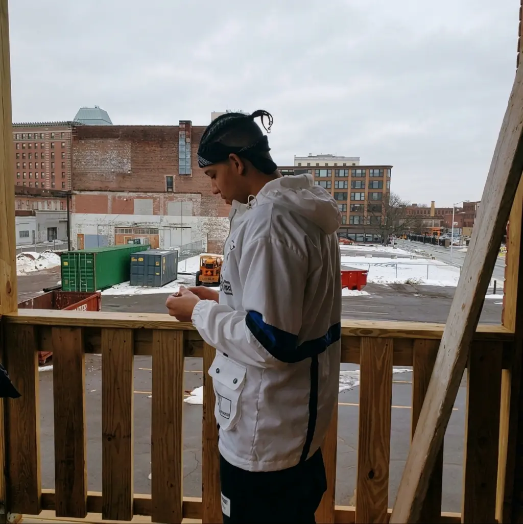 AlexOnGame92 on a balcony overlooking a winter city block